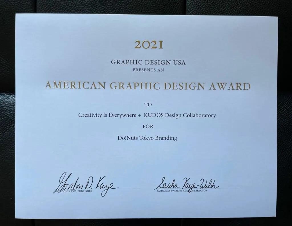 The 2021 American Graphic Design Award certificate for DO! NUTS TOKYO branding, awarded to creativity is everywhere with KUDOS Design Collaboratory