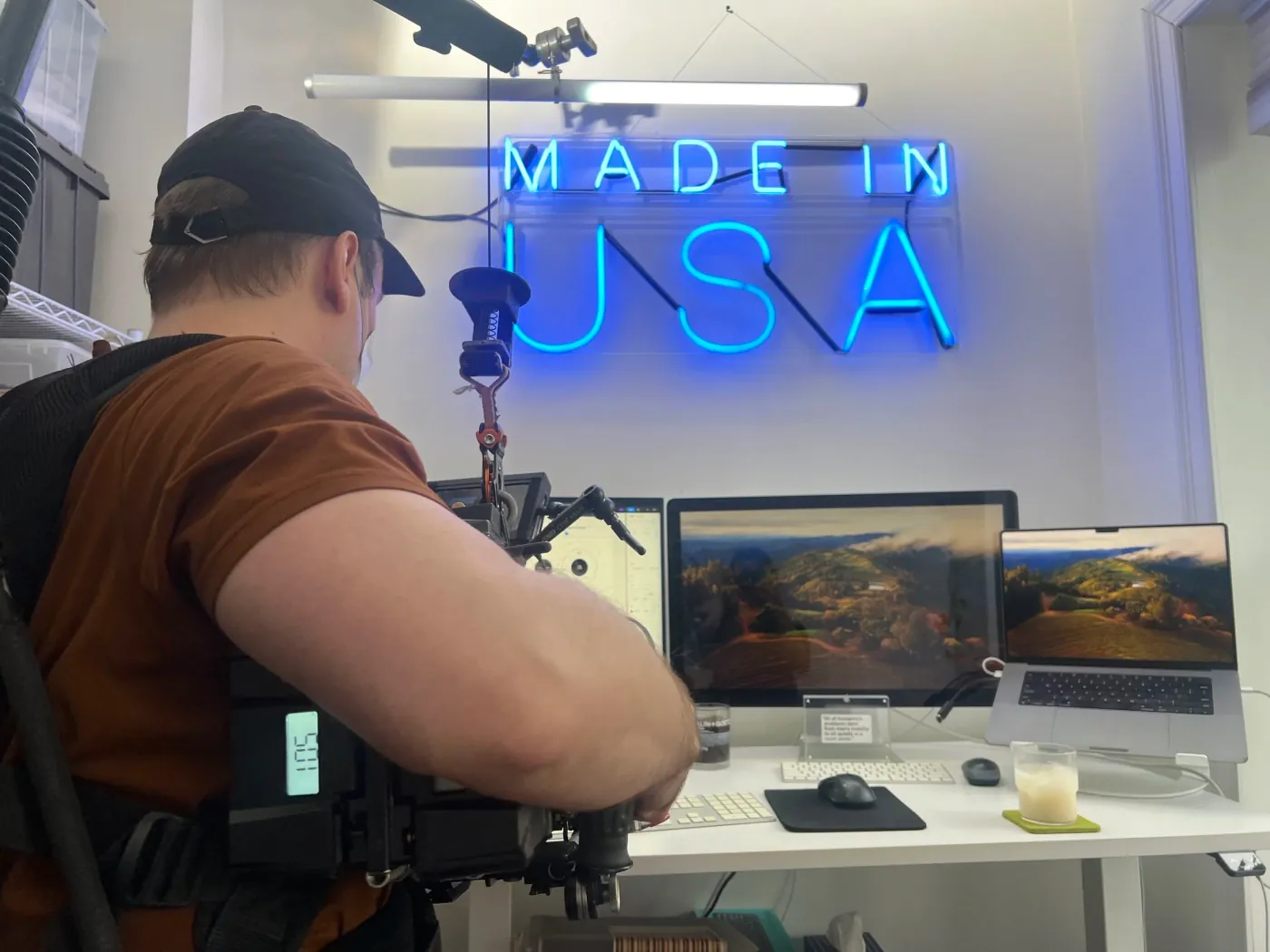 A camera operator filming inside a neon-lit creative studio