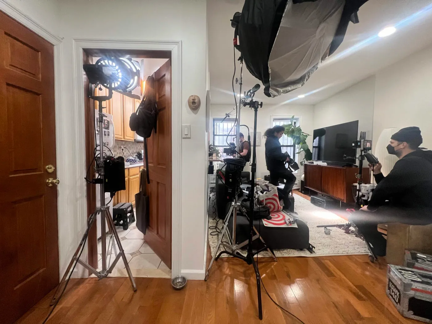 Film crew, cameras, lights, and sound equipment set up inside a New York home